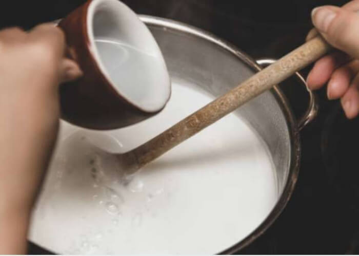 Перелейте молоко в эмалированную или нержавеющую кастрюлю с толстым дном.  Нагрейте его до 92°С, постоянно помешивая.