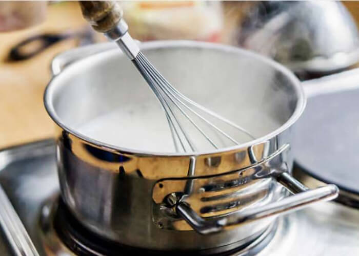 Налейте молоко в кастрюлю и поставьте на плиту. В этом рецепте его надо довести до кипения, но не кипятить.