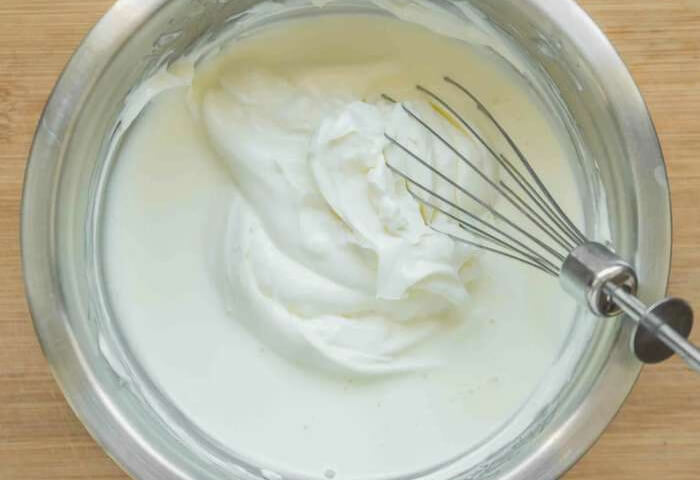 Добавьте ванильный экстракт и начинайте вводить сахарную пудру небольшими порциями. Перемешивайте крем на минимальных оборотах и не забывайте снимать массу со стенок посуды.