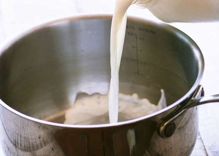 Кислое молоко влейте в кастрюлю с толстым дном, добавьте взбитое яйцо и паприку.