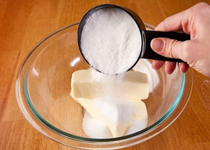 Размягченное масло поместите в емкость, добавьте туда сахарную пудру и ванильный сахар. Миксером взбейте смесь до пышности.