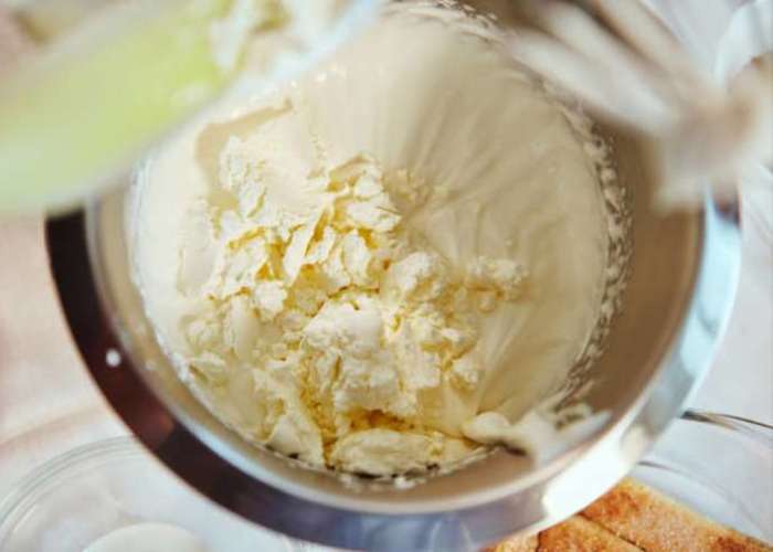 В несколько приемов добавьте сыр к взбитой масляно-сахарной смеси, одновременно взбивая смесь на низких оборотах. Продолжайте работать миксером в этом же режиме еще пару минут.