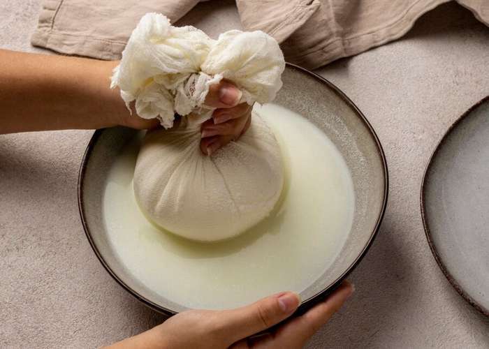 Поместите сыр в марлевый мешочек и подвесьте его над кастрюлей на пару часов, чтобы стекала жидкость.