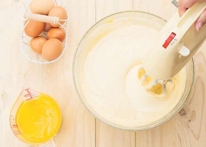 В глубокой посуде взбейте миксером яйца со сливочным маслом.