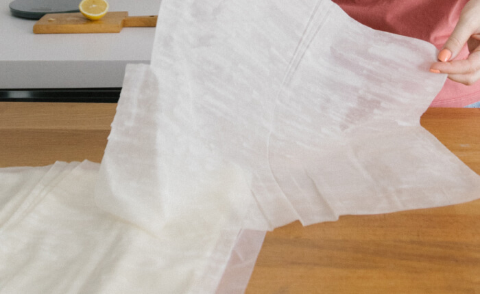 Накройте сито чистой хлопчатобумажной тканью, сложенной в 2-3 раза (в качестве альтернативного варианта можно воспользоваться марлей). Свободные концы ткани в дальнейшем будут завязаны в узел, поэтому длина отрезка должна быть соответствующей.