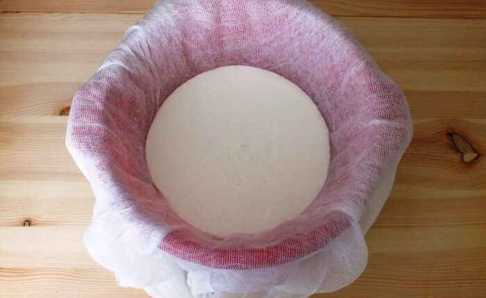 Застелите дуршлаг куском лавсана, льняной салфеткой или марлей, сложенной в 10 слоев и установите его в глубокую миску (или кастрюлю).