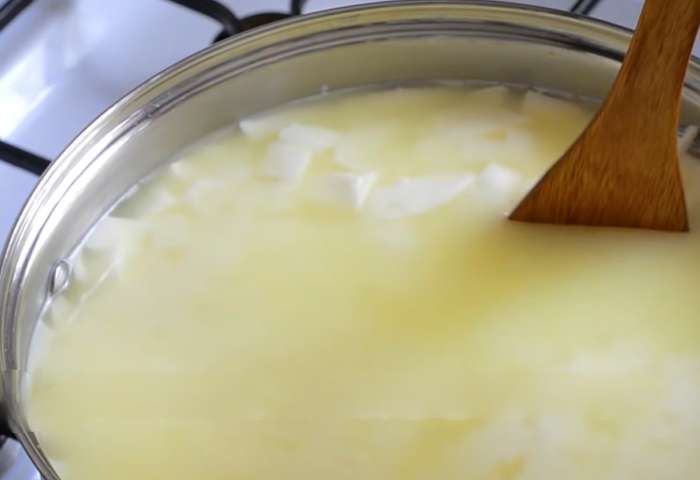 В течение 35 минут при температуре 32°C помешивайте сырное зерно, размельчая крупные куски. Не измельчайте зерно слишком сильно. Оно должно уменьшиться до 7-8 мм.