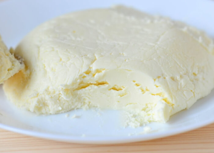 Примерно через 12 часов, согласно рецепту, сыр обретет достаточную плотность, его можно использовать для приготовления различных блюд, а также употреблять в пищу как самостоятельный продукт. Сыворотку не стоит утилизировать, так как на ее можно добавлять в выпечку, десерты и полезные для здоровья напитки.