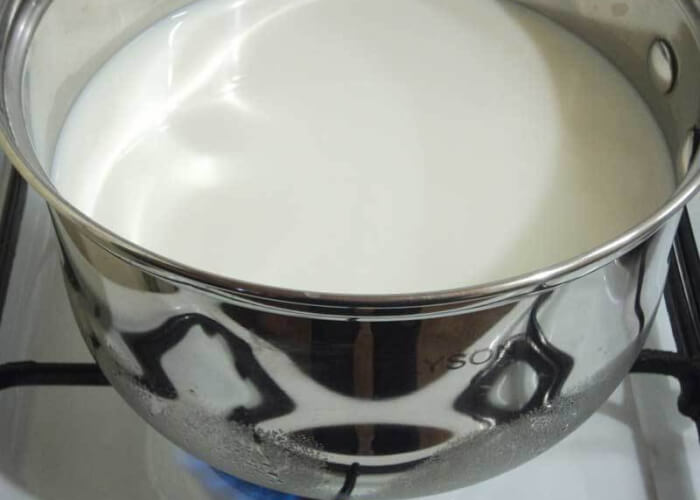 Вскипятите домашнее молоко в кастрюле с толстым дном и остудите до комнатной температуры.