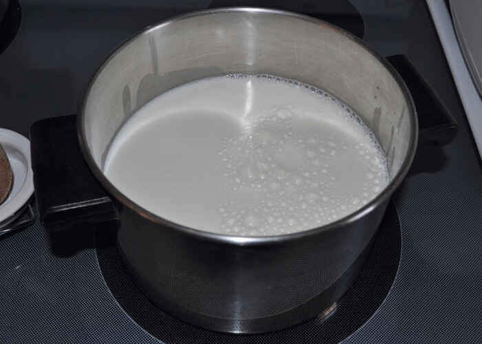Перелейте молоко в глубокую кастрюлю с толстым дном, поставьте на медленный огонь и доведите до кипения.