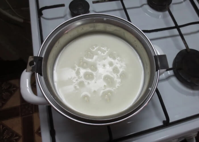 Варите молоко с творогом на небольшом огне примерно 20-25 минут, постоянно помешивая.