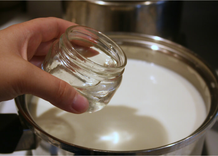 Добавьте в подогретое молоко хлористый кальций и сычужный фермент, тщательно все размешайте, снимите с плиты и оставьте при комнатной температуре примерно на полчаса. За это время в кастрюле должен сформироваться сырный сгусток из молока, достаточно плотный и упругий. Это важное условие, без которого вы вряд ли сможете узнать что такое качественный халлуми.